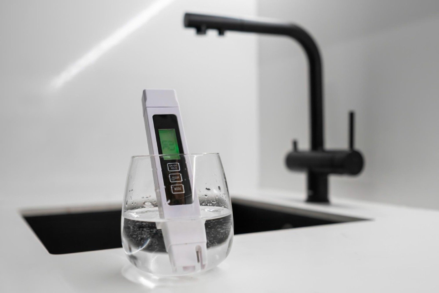 TDS meter testing water quality at the kitchen tap